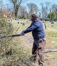 Willie Montague pulls vines at Woodland Cemetery in early March of this year.
