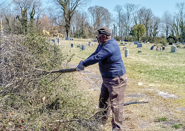 Willie Montague pulls vines at Woodland Cemetery in early March of this year.