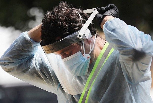 LOS ANGELES, CALIFORNIA  - JULY 07: A COVID-19 testing associate adjusts his personal protective equipment (PPE) at a testing center at Lincoln Park amid the coronavirus pandemic on July 07, 2020 in Los Angeles, California. There has been a spike in new coronavirus cases in California along with an increase in the overall positivity rate and number of hospitalizations. (Photo by Mario Tama/Getty Images)/Credit:	Mario Tama/Getty Images