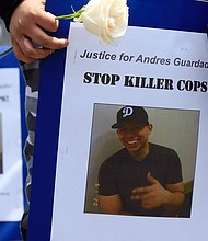 Mourners hold images of Andres Guardado, 18, who was fatally shot by a Los Angeles County sheriff's deputy, at a memorial site in Gardena, Calif., Friday, June 19, 2020./Credit:	Damian Dovarganes/AP