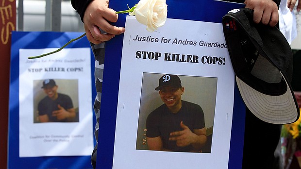 Mourners hold images of Andres Guardado, 18, who was fatally shot by a Los Angeles County sheriff's deputy, at a memorial site in Gardena, Calif., Friday, June 19, 2020./Credit:	Damian Dovarganes/AP