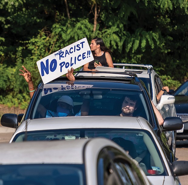 About 100 cars parade along Oliver Hill Way for the “Free Them All Car Rally” on Independence Day outside the Richmond Justice Center. People decorated their vehicles and held signs through sunroofs calling for prison reform and the release of inmates during the COVID-19 pandemic.