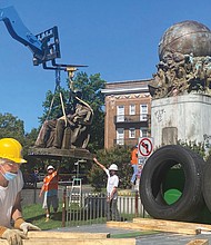 Sculptor Paul DiPasquale prepares the place on the flatbed truck where the statue of Confederate naval commander Matthew Fontaine Maury will be placed. The bronze statue was taken down July 2 under the watchful eye of Mr. DiPasquale, a consultant to the city on removing the statues.