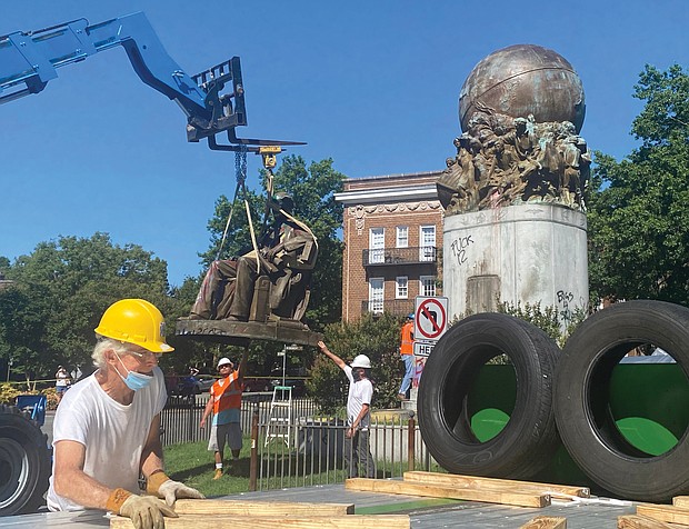 Sculptor Paul DiPasquale prepares the place on the flatbed truck where the statue of Confederate naval commander Matthew Fontaine Maury will be placed. The bronze statue was taken down July 2 under the watchful eye of Mr. DiPasquale, a consultant to the city on removing the statues.