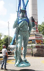 The statue of a Confederate private faces forward Wednesday after being taken off its towering pedestal in Libby Hill Park, where it has stood for 126 years. The monument was placed on the hilltop in 1894 overlooking the site where the Confederate Navy Yard operated during the Civil War.