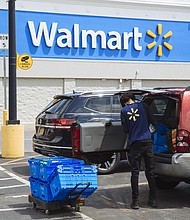 A worker delivers groceries to a customer's vehicle outside a Walmart Inc. store in Amsterdam, New York, U.S., on Friday, May 15, 2020. With the spread of coronavirus slowing in New York, Governor Andrew Cuomo said Monday the state economy is ready to begin reopening, with some regions authorized to do so as soon as this week./Credit:	Angus Mordant/Bloomberg/Getty Images