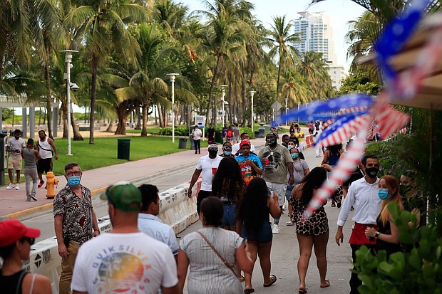 People walk past restaurants on Ocean Drive on July 03, 2020 in the South Beach neighborhood of Miami Beach, Florida. In order to prevent the spread of COVID-19, Miami-Dade county has closed beaches from July 3-7 and imposed a curfew from from 10pm to 6am./Credit:	Cliff Hawkins/Getty Images