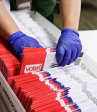 Election workers sort vote-by-mail ballots for the presidential primary at King County Elections in Renton, Washington, on March 10, 2020/Credit:	JASON REDMOND/AFP/Getty Images