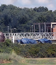 Parts of three tarp-covered Confederate statues are visible from Interstate 95 outside the city Wastewater Treatment Plant located off Maury Street in South Side. The globe that sat behind the statue of Confederate Matthew Fontaine Maury on Monument Avenue appears to be under one tarp.