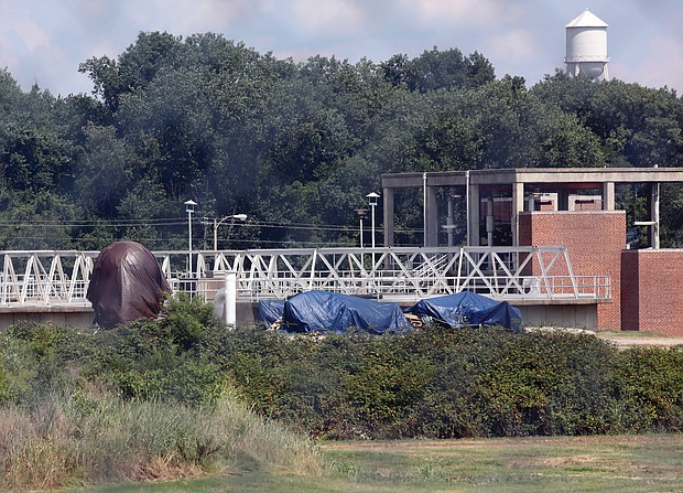 Parts of three tarp-covered Confederate statues are visible from Interstate 95 outside the city Wastewater Treatment Plant located off Maury Street in South Side. The globe that sat behind the statue of Confederate Matthew Fontaine Maury on Monument Avenue appears to be under one tarp.