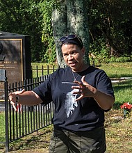 LaChandra L. Pace pauses during last Saturday’s cleanup at historic Woodland Cemetery in Henrico County to talk with volunteers about her uncle, tennis champion and human rights advocate Arthur Ashe Jr., who is buried in the cemetery. The Woodland Cemetery Volunteers held a “birthday cleanup” in honor of Mr. Ashe, who would have been 77 on July 10. Mr. Ashe is one of dozens of African-American luminaries buried in the private cemetery at 2300 Magnolia Road that dates to 1916.