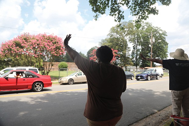 Sonya Beaver, 50, left, waves with her mother, Helen Beaver, 78, as a U.S. Census parade passes by on Clarkson Road in South Side on Saturday. The parade, featuring cars and motorcycles from the Victory 7 Mustang Club and the Buffalo Soldiers Motorcycle Club, was to encourage city residents to complete and return their census forms.