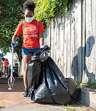 The National Park Service, which preserves her home at 1101⁄2 E. Leigh St. as a national historic site, and the city Department of Parks, Recreation and Community Facilities, sponsored the day, which drew volunteers to help with a vari- ety of community projects. Volunteers Nia Brown, front, and Ebonee Henry pick up litter in the 500 block of Brook Road, while others work on a fence mural of Mrs. Walker outside the Calhoun Family Investment Center in Gilpin Court.