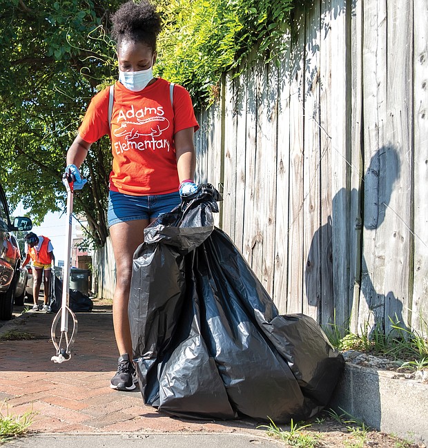The National Park Service, which preserves her home at 1101⁄2 E. Leigh St. as a national historic site, and the city Department of Parks, Recreation and Community Facilities, sponsored the day, which drew volunteers to help with a vari- ety of community projects. Volunteers Nia Brown, front, and Ebonee Henry pick up litter in the 500 block of Brook Road, while others work on a fence mural of Mrs. Walker outside the Calhoun Family Investment Center in Gilpin Court.