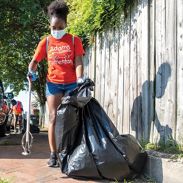 The National Park Service, which preserves her home at 1101⁄2 E. Leigh St. as a national historic site, and the city Department of Parks, Recreation and Community Facilities, sponsored the day, which drew volunteers to help with a vari- ety of community projects. Volunteers Nia Brown, front, and Ebonee Henry pick up litter in the 500 block of Brook Road, while others work on a fence mural of Mrs. Walker outside the Calhoun Family Investment Center in Gilpin Court.