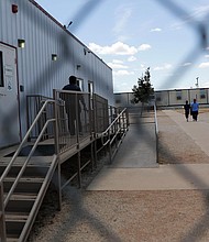 Immigrants seeking asylum walk at the ICE South Texas Family Residential Center, August 2019, in Dilley, Texas./Credit:	Eric Gay/AP
