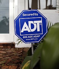 An ADT home security alarm sign is seen in front of a home on February 16, 2016 in Miami, Florida. It was announced that home security firm ADT was purchased by private equity firm Apollo Global Management for $6.9 billion./Credit:	Joe Raedle/Getty Images