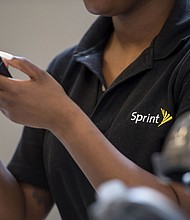 An employee checks an Apple Inc. iPhone for a customer inside a Sprint Corp. store in San Francisco, California on May 5, 2016. T-Mobile US Inc. agreed to acquire Sprint Corp. for $26.5 billion in stock, a wager that the carriers can team up to build a next-generation wireless network and get a jump on industry leaders Verizon Communications Inc. and AT&T Inc./Credit:	David Paul Morris/Bloomberg/Getty Images