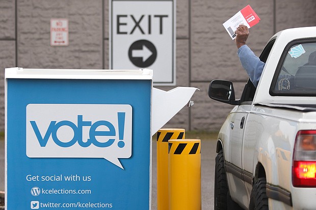 Voters drop off their presidential primary mail-in ballots at a drop box at King County Elections in Renton, Washington on March 10, 2020./Credit:	JASON REDMOND/AFP/Getty Images