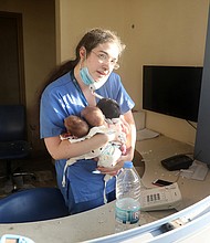 A nurse takes care of three babies in a damaged hospital after the explosion in Beirut, Lebanon./Credit:	Bilal Jawich/Xinhua via Getty