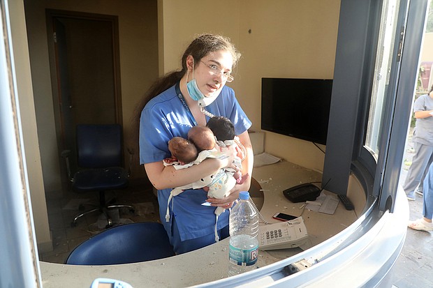 A nurse takes care of three babies in a damaged hospital after the explosion in Beirut, Lebanon./Credit:	Bilal Jawich/Xinhua via Getty