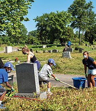 Volunteers clean Woodland Cemetery last month in honor of Arthur Ashe’s birthday.
