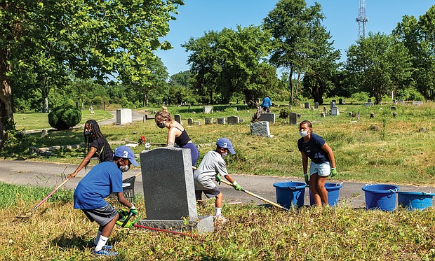 Volunteers clean Woodland Cemetery last month in honor of Arthur Ashe’s birthday.