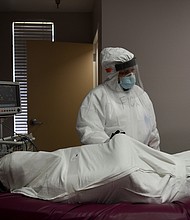 The body of a patient, who died during an intubation procedure, is prepared by Flor Trevino, 39, a nurse, to be transported to a morgue, at United Memorial Medical Center (UMMC), during the coronavirus disease (COVID-19) outbreak, in Houston, Texas./Credit:	Callaghan O'Hare/Reuters