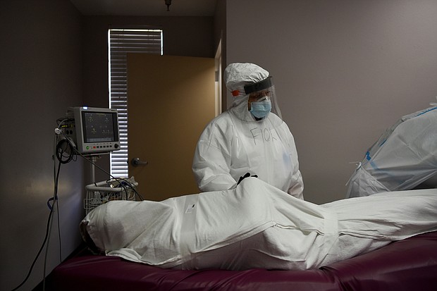 The body of a patient, who died during an intubation procedure, is prepared by Flor Trevino, 39, a nurse, to be transported to a morgue, at United Memorial Medical Center (UMMC), during the coronavirus disease (COVID-19) outbreak, in Houston, Texas./Credit:	Callaghan O'Hare/Reuters