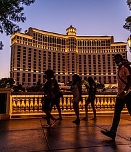 Pedestrians pass in front of the Bellagio Hotel and Casino at night in Las Vegas, Nevada, U.S., on Sunday, July 26, 2020. MGM Resorts International is scheduled to releasing earnings figures on July 30. Photographer: Roger Kisby/Bloomberg via Getty Images/Credit:	Roger Kisby/Bloomberg/Getty Images