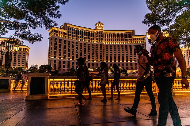 Pedestrians pass in front of the Bellagio Hotel and Casino at night in Las Vegas, Nevada, U.S., on Sunday, July 26, 2020. MGM Resorts International is scheduled to releasing earnings figures on July 30. Photographer: Roger Kisby/Bloomberg via Getty Images/Credit:	Roger Kisby/Bloomberg/Getty Images