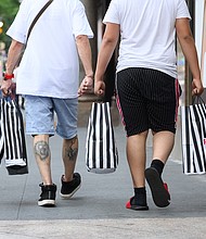People carry Foot Locker bags  outside Macy's Herald Square as the city moves into Phase 2 of re-opening following restrictions imposed to curb the coronavirus pandemic on June 23, 2020 in New York City. Phase 2 permits the reopening of offices, in-store retail, outdoor dining, barbers and beauty parlors and numerous other businesses. Phase 2 is the second of four-phased stages designated by the state./Credit:	Noam Galai/Getty Images
