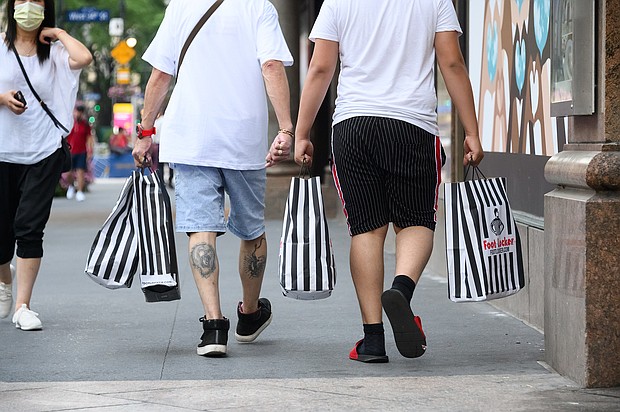 People carry Foot Locker bags  outside Macy's Herald Square as the city moves into Phase 2 of re-opening following restrictions imposed to curb the coronavirus pandemic on June 23, 2020 in New York City. Phase 2 permits the reopening of offices, in-store retail, outdoor dining, barbers and beauty parlors and numerous other businesses. Phase 2 is the second of four-phased stages designated by the state./Credit:	Noam Galai/Getty Images