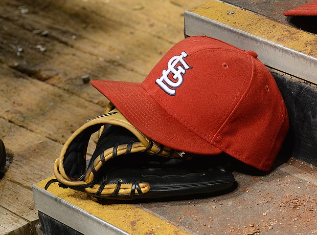A detailed view of a St. Louis Cardinals baseball hat and glove sitting in the dugout during the game against the Chicago Cubs at Busch Stadium on May 12, 2014 in St Louis, Missouri. The Cubs defeated the Cardinals 17-5./Credit:	Mark Cunningham/Getty Images