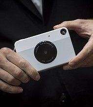 An exhibitor holds the Eastman Kodak Co. Printomatic instant print camera during the 2018 Consumer Electronics Show (CES) in Las Vegas, Nevada, U.S., on Wednesday, Jan. 10, 2018. Electric and driverless cars will remain a big part of this year's CES, as makers of high-tech cameras, batteries, and AI software vie to climb into automakers' dashboards./Credit:	David Paul Morris/Bloomberg/Getty Images
