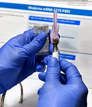 Nurse Kathe Olmstead prepares a shot as the world's biggest study of a possible COVID-19 vaccine, developed by the National Institutes of Health and Moderna Inc., gets underway in Binghamton, N.Y. (AP Photo/Hans Pennink)/Credit:	Hans Pennink/AP