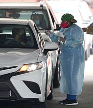 A health care worker directs a person to use a nasal swab for a self administered test at the new federally funded COVID-19 testing site at the Miami-Dade County Auditorium on July 23, 2020 in Miami, Florida. Vice Admiral Jerome Adams, the U.S. Surgeon General, visited the site, as the state of Florida experiences a spike in coronavirus cases, to encourage people to wear a mask and take other precautions to fight the pandemic./Credit:	Joe Raedle/Getty Images
