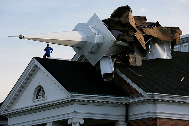 A person surveys the damage from the roof of College Church in Wheaton, Illinois after a severe storm toppled the church steeple on the campus of Wheaton College on Aug. 10, 2020./Credit:	Mark Hume/Chicago Tribune/Tribune News Service/Getty Images