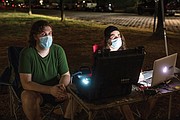 Alex Criqui, left, and Dustin Klein bring their understanding of history and technology to their nightly projections of images of African-Americans onto the Lee statue at Monument Avenue.