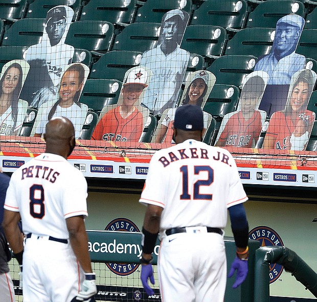 Houston Astros third base coach Gary Pettis and manager Dusty Baker Jr. look into the stands at photo cutouts of former Negro League players during a celebration of the 100th anniversary of the Negro Leagues before a game against the Seattle Mariners on Aug. 16 at Minute Maid Park.