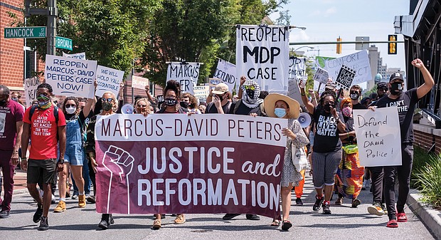 Marchers call for reopening the investigation into the 2018 fatal police shooting of Marcus-David Peters in Richmond during its march along Broad Street toward the legislative session at the Siegel Center. the state Senate is meeting at the Science Museum of Virginia.