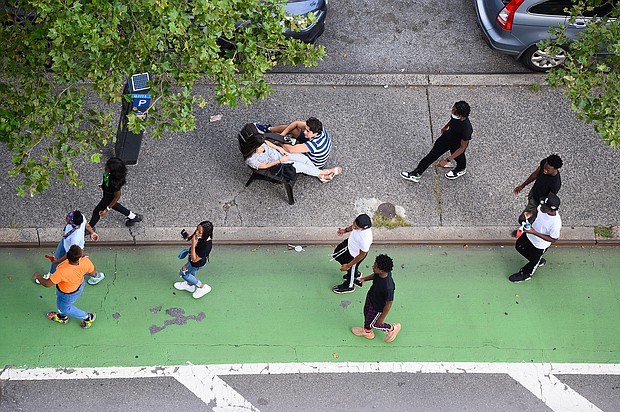 People sit on a traffic island in Kips Bay as the city continues Phase 4 of re-opening following restrictions imposed to slow the spread of coronavirus on August 17, 2020 in New York City./Credit:	Noam Galai/Getty Images