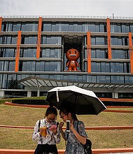 Two visitors in front Taobao model of Office Building at Alibaba Xixi Park on July 13, 2017 in Hangzhou, Zhejiang province of China. Alibaba sales soar but a crackdown from the US may be looming.
\Credit: Wang He/Getty Images