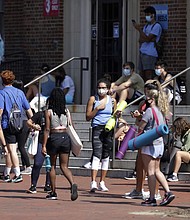 University of North Carolina students wait outside of Woolen Gym on the Chapel Hill, N.C., campus as they wait to enter for a fitness class Monday, Aug. 17, 2020. The University announced minutes before that all classes will be moved online starting Wednesday, Aug. 19 due to COVID clusters on campus./Credit:	Julia Wall/The News & Observer via AP