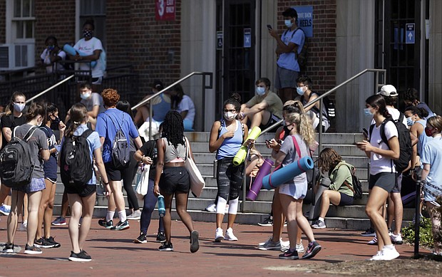 University of North Carolina students wait outside of Woolen Gym on the Chapel Hill, N.C., campus as they wait to enter for a fitness class Monday, Aug. 17, 2020. The University announced minutes before that all classes will be moved online starting Wednesday, Aug. 19 due to COVID clusters on campus./Credit:	Julia Wall/The News & Observer via AP