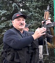 President Alexander Lukashenko brandishing a rifle near the Palace of Independence in Minsk, Sunday, as seen in video from state TV./Credit:	State TV and Radio Company of Belarus via AP