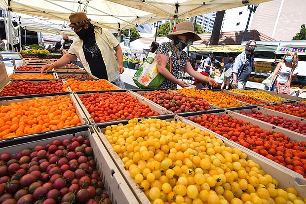 People wear face coverings shop for tomatoes at the Santa Monica Farmers' Market in Santa Monica, California./Credit:	Robyn Beck/AFP/Getty Images