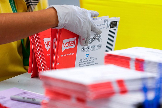 An election worker opens envelopes containing vote-by-mail ballots for the August 4 Washington state primary at King County Elections in Renton, Washington./Credit:	JASON REDMOND/AFP/Getty Images