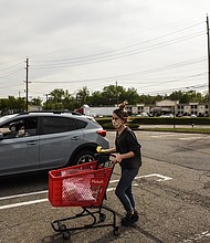 An employee of Michaels retail store delivers an order to a customer waiting outside in their car on May 18, 2020 in Paramus, New Jersey./Credit:	Stephanie Keith/Getty Images