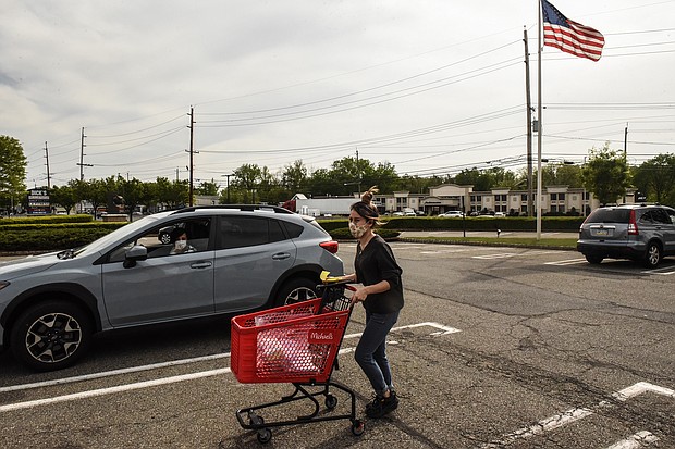 An employee of Michaels retail store delivers an order to a customer waiting outside in their car on May 18, 2020 in Paramus, New Jersey./Credit:	Stephanie Keith/Getty Images